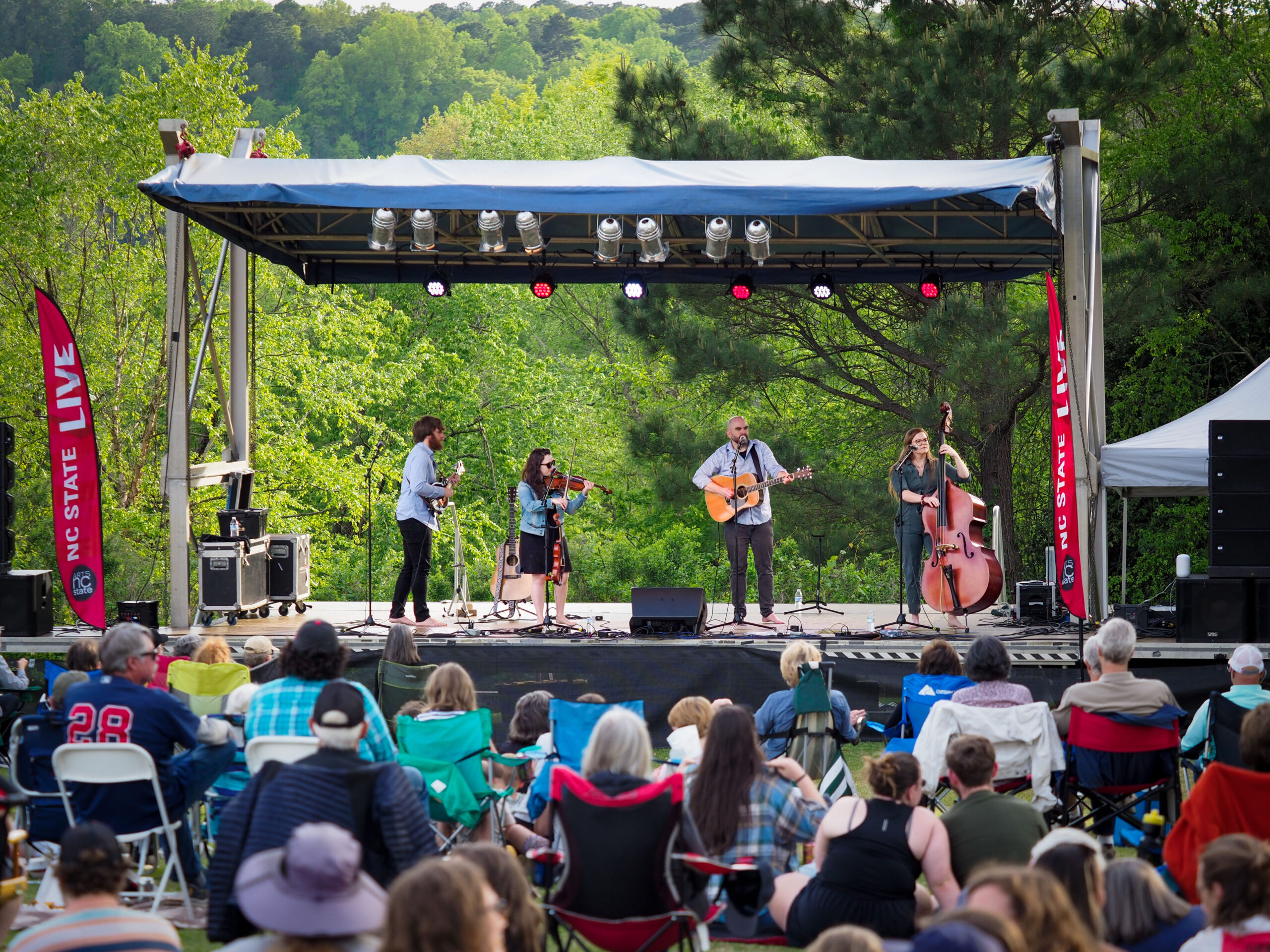 Specators enjoy live music from a bluegrass band at Live at the Lake, 2022. Arts NC State at Lake Raleigh. Photo by Marc Hall