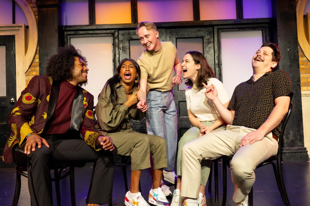 Members of The Second City laughing on stage