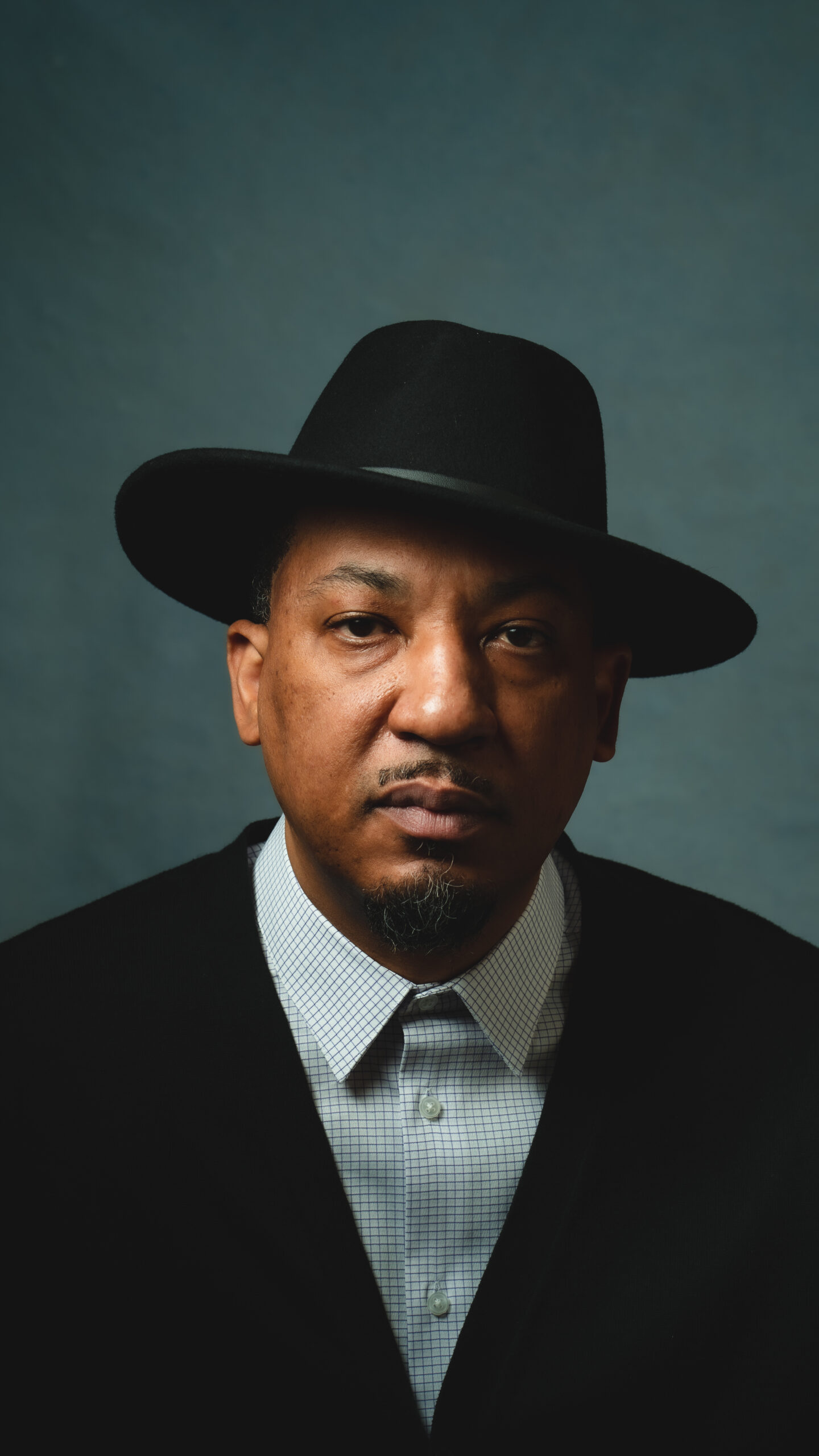 Dasan Ahanu looks directly at the camera while wearing a brimmed hat.