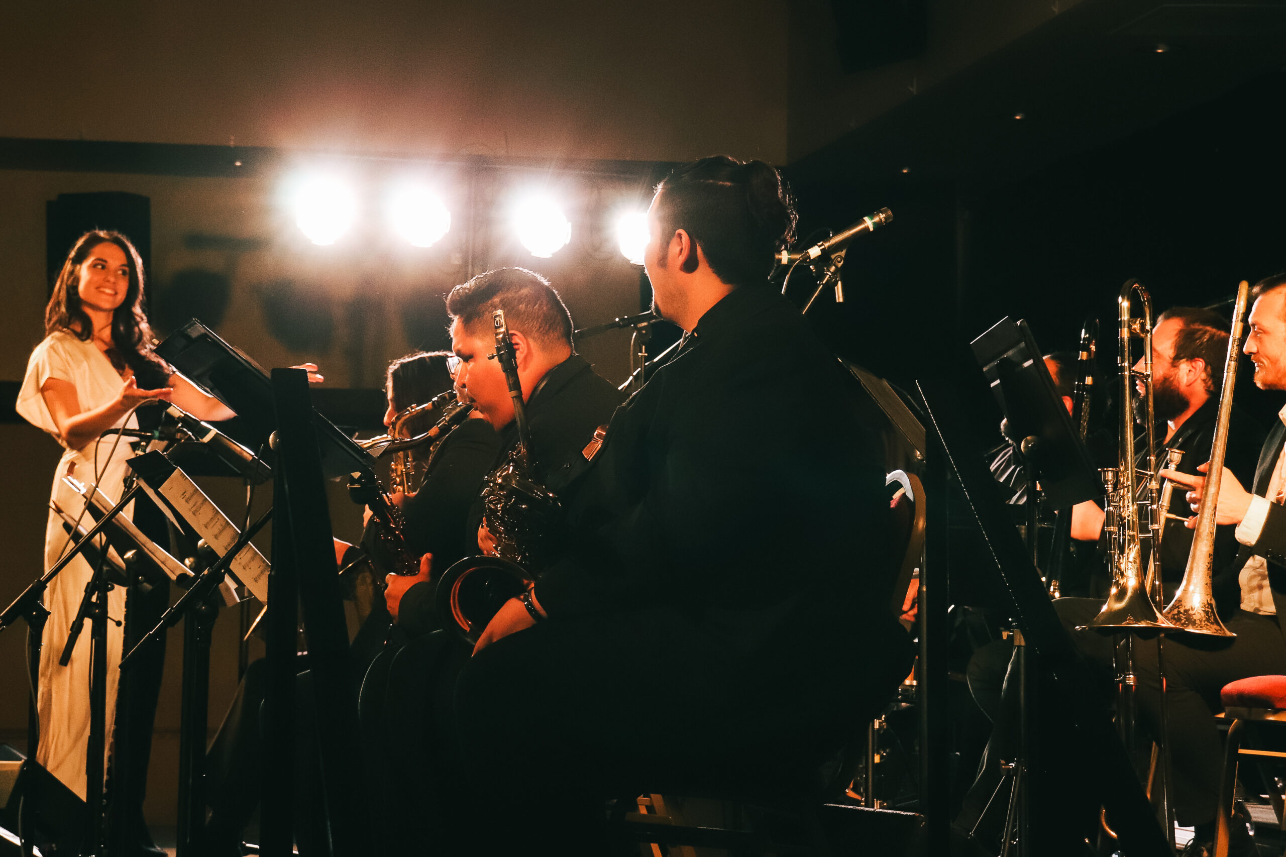 Julia Keefe stands in front of brass section while conducting.
