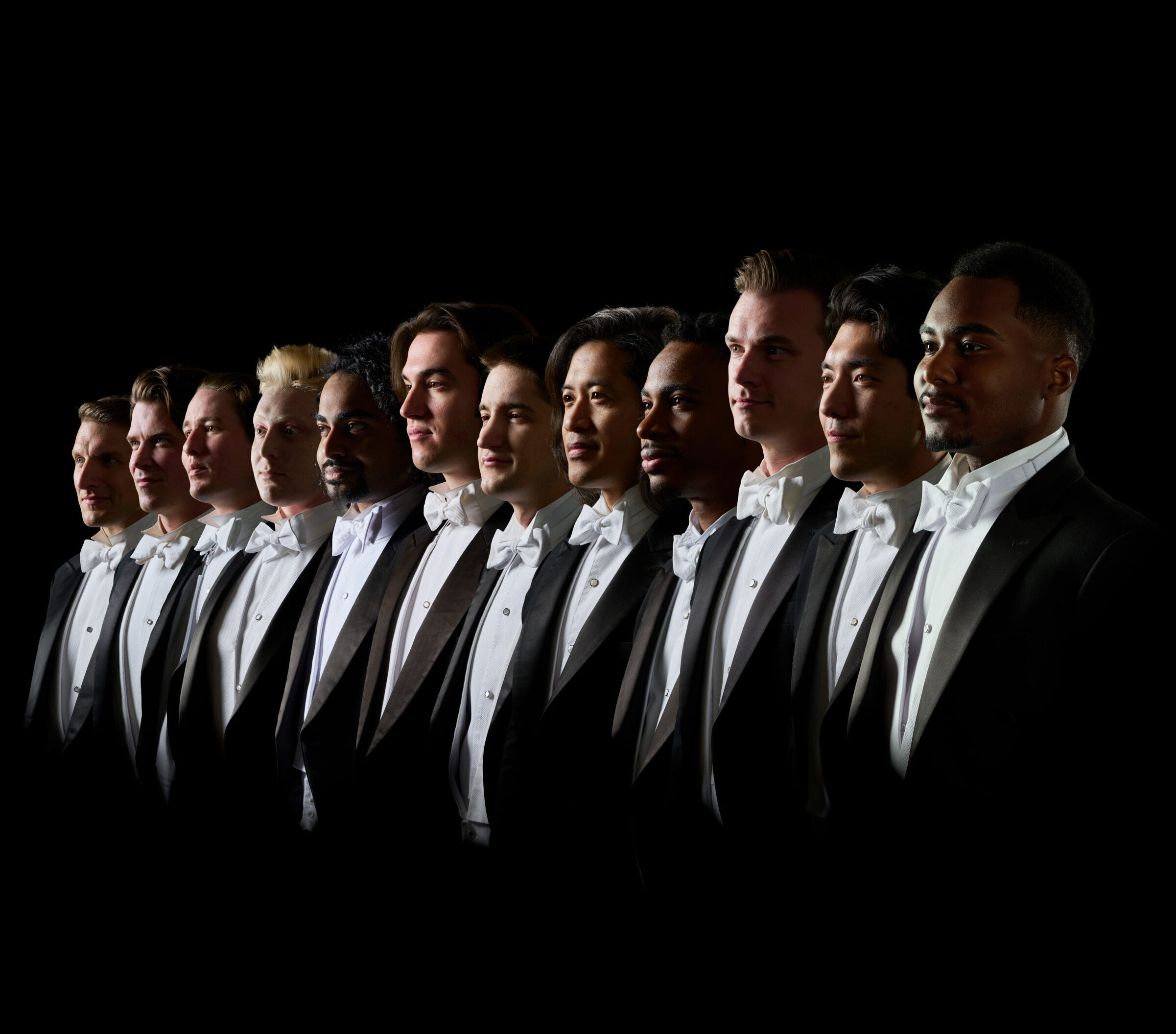Members of Chanticleer stand in a line in matching tuxedoes.
