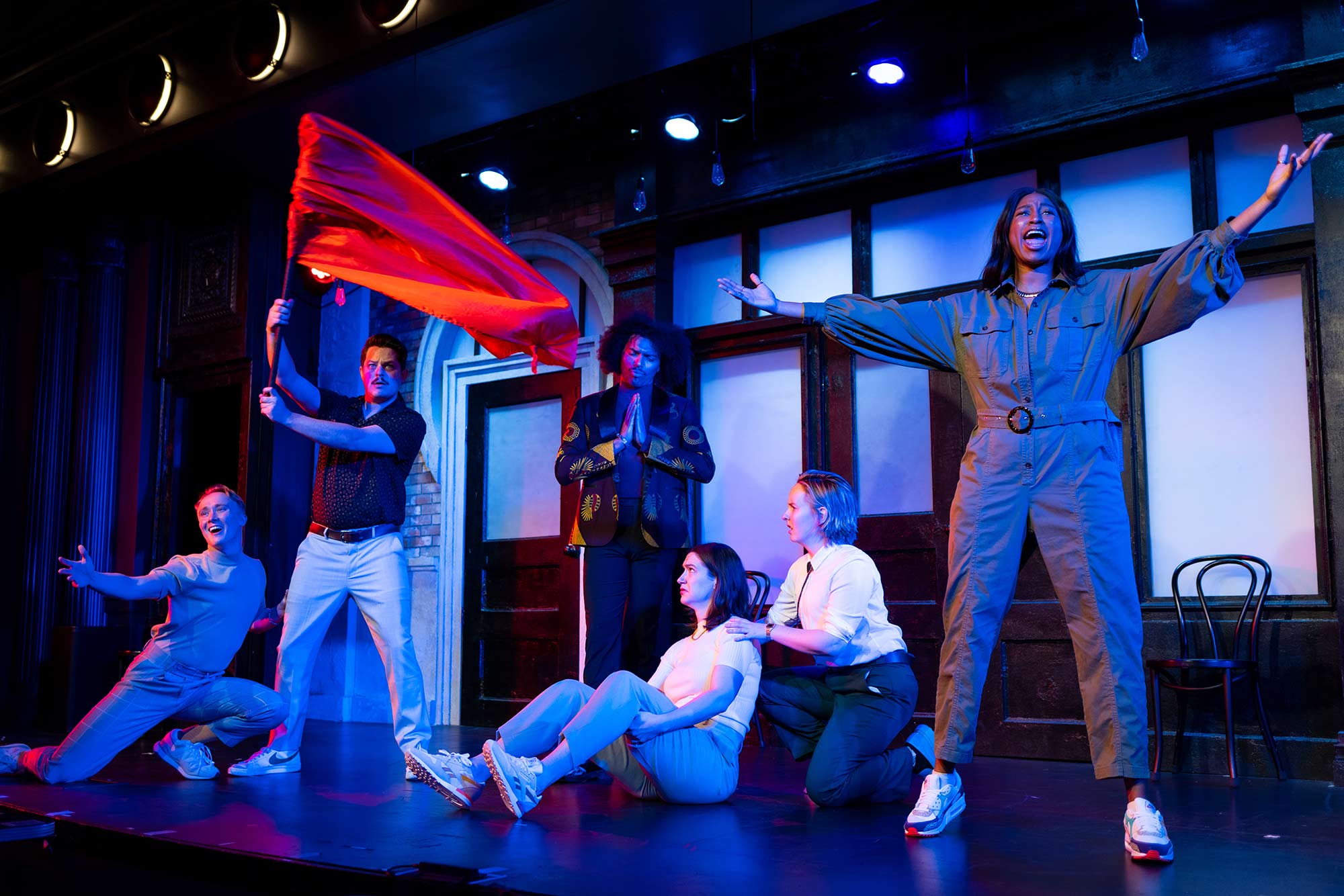 The Second City cast members perform improvisation on stage.